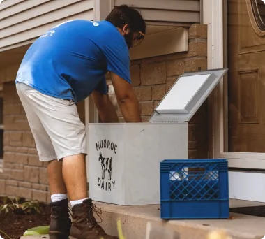 Munroe Dairy milkman delivering to a doorstep milk box